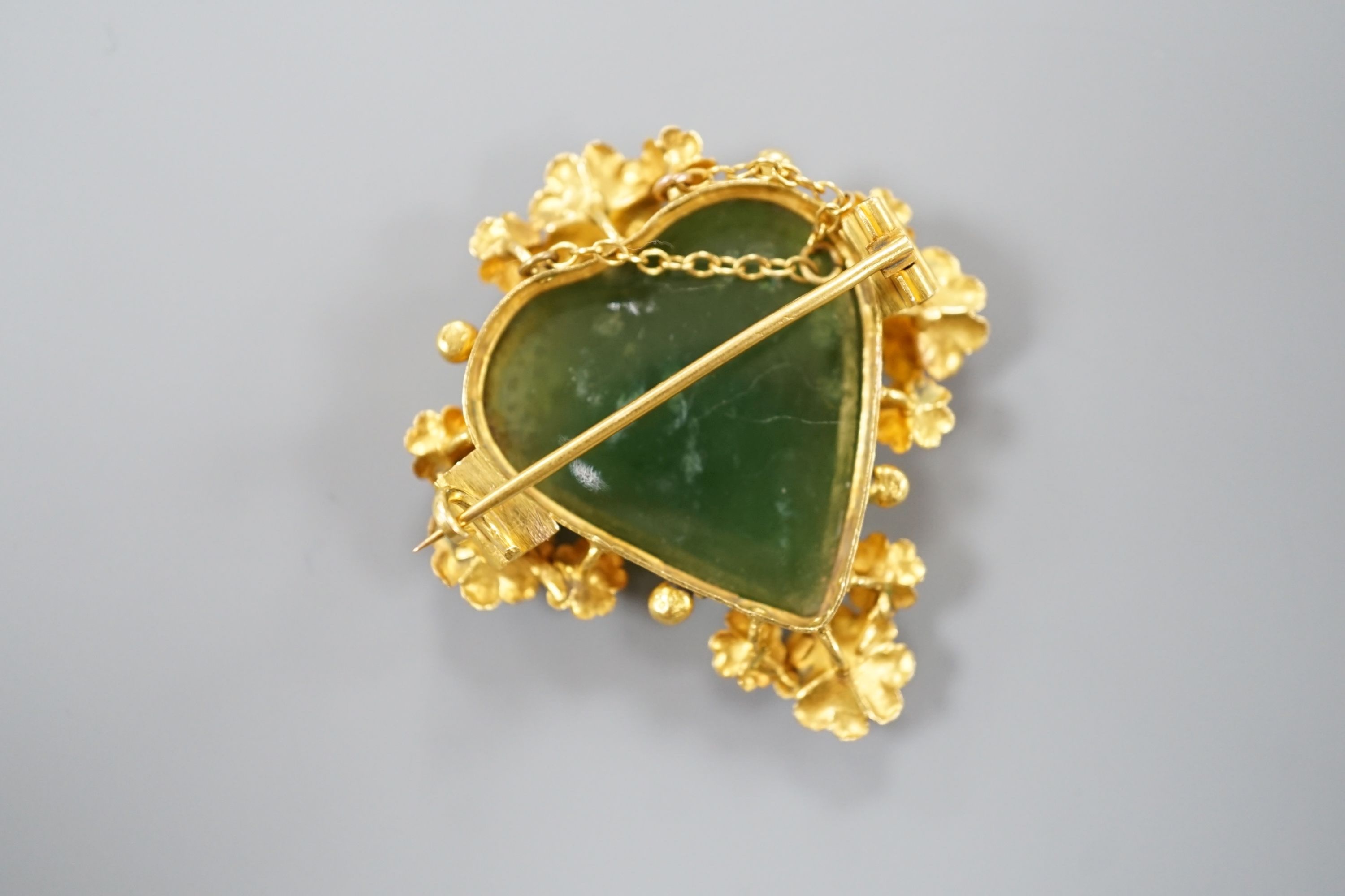 A yellow metal mounted nephrite heart shaped brooch, 41mm, gross weight 11.9 grams.